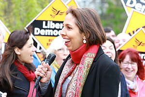 Munira Wilson in front of a crowd holding Liberal Democrat posters